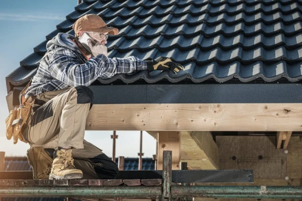 roof construction worker making phone call while staying on scaffolding